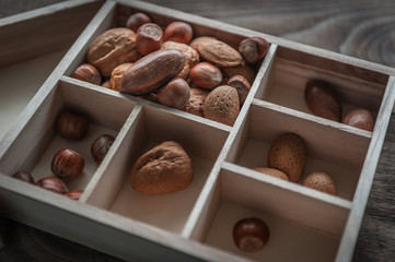 Healthy mix nuts on wooden background. Walnut, hazelnut, almond and pecan. Selective focus