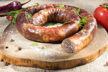 A ring of cooked sausage on the grill.
