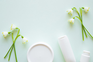 Jar, tube and bottle of natural herbal cream for women. Beautiful, fresh snowdrop flowers. Care about clean and soft hands, legs and body skin. Empty place for text or logo.