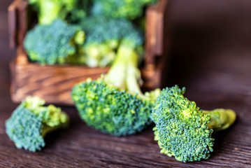 Fresh broccoli in wooden box on wooden surface