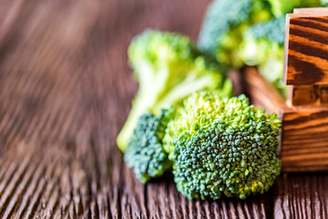 Fresh broccoli in wooden box on wooden surface