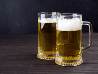 Two glasses of lager served on old wooden planks, copyspace for text