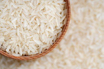 Healthy food. Long parboiled rice in wooden bowl on blurred background. Close up. Top view, high resolution product