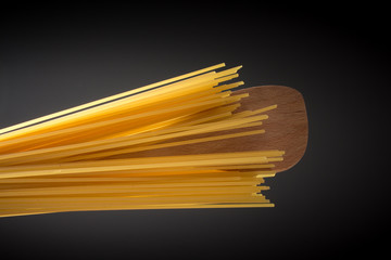 Spaghetti und Kochl&ouml;ffel dunkler Hintergrund