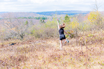 Naklejka na ściany i meble Young athletic, fit, free happy woman running jogging jumping in autumn, fall, summer meadow field path hike in mid-air, muscles