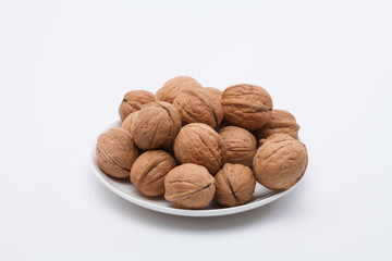 Walnuts on white dish on the white background 