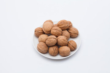 Walnuts on white dish on the white background 