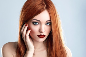 Fototapeta premium Fashion Beauty Model Woman Long Red Hair. Red Matte Lips and Nails. Blue Eyes.