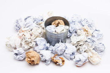 Crumpled business papers with metal pot concept view on white 