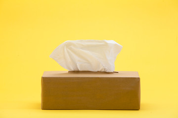 Paper tissues in brown box on yellow background