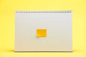 Yellow sticker on table calendar on yellow surface 