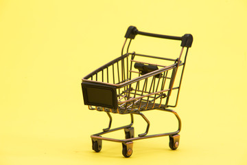 Brown shopping trolley cart on yellow 