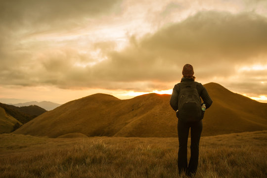 Female hiker standing on a mountain looking at the beautiful view. Location Philippines Mt Pulag.