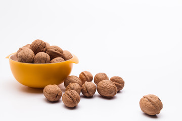 Yellow bowl full of walnuts isolated