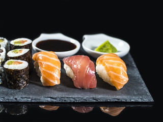 Close up Sushi Set on Slate with Tuna and Salmon Sushis, Wasabi on Black Background