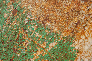 painted iron surface with a large rusty and metal corrosion, chipped paint, old background with peeling and cracking paint, green texture