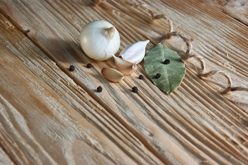 Garlic, onion, bay leaf, black pepper on a wooden table. Food background. Garlics. sliced garlic, garlic clove, garlic bulb.