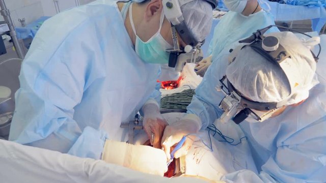 Doctors are performing a surgery on an upper-body and lower-body simultaneously