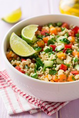 Fresh salad with bulgur and vegetables in bowl on wooden table