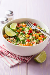 Fresh salad with bulgur and vegetables in bowl on wooden table