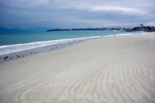 Sand texture on Vao beach with Samil beach in background, Vigo, Galicia, Spain