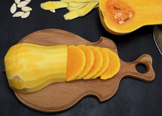 half of peeled pumpkin on wooden cutting board