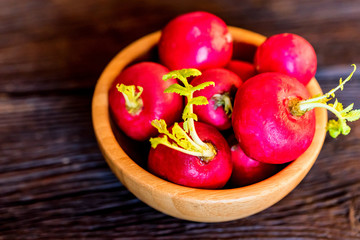 Fresh red radishes in wooden bowl close