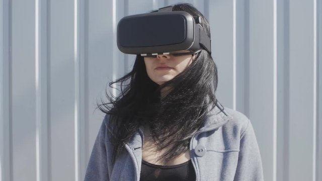 Young woman using virtual reality headset outdoor