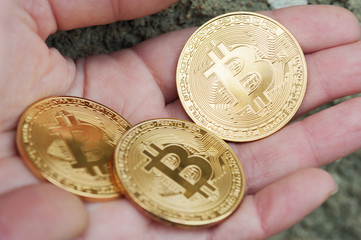  female hands hold the three coin on the dark background