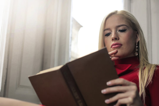 Blonde woman reading a book