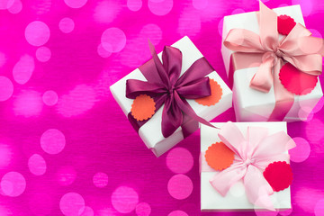 Composition three white boxes with a Satin ribbon Bow Background Saturation pink.