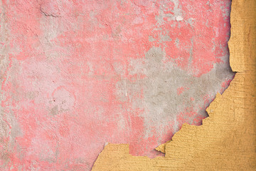 Pink wall with crumbled yellow plaster