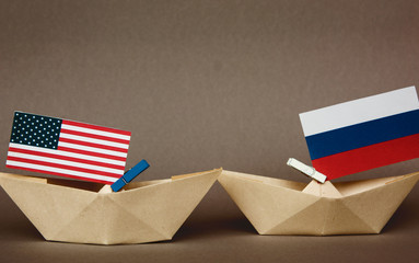 paper ship with Flags of USA and Russia. conflict in Syria sea, concept shipment or free trade...