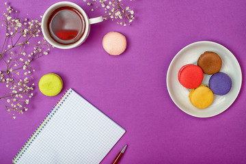 Colorful sweet macaroons and a cup of tea. Delicious breakfast. Romantic mood.Plans for the day.	