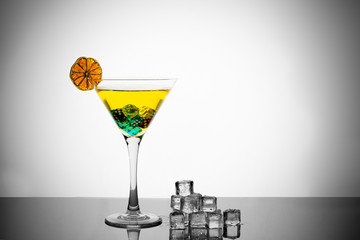 Martini glass with dry lime and ice on white background.