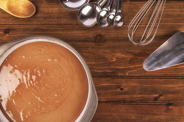 Freshly cooking chocolate cake, utensil on wooden table. Top view.