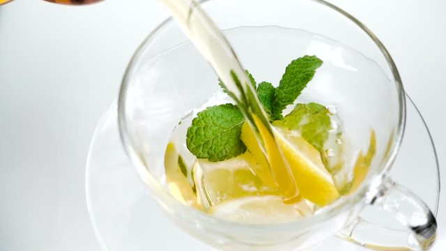 tea in cup with leaf mint and lemon on white background