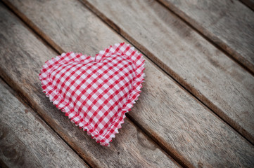 Fototapeta premium Closeup of fabric shaped heart on woden table background