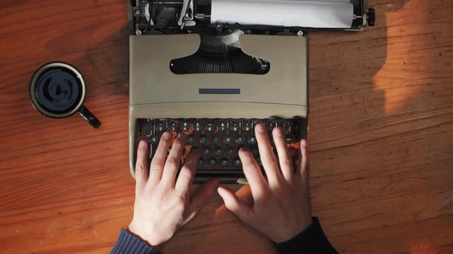 Book writing by the window with a vintage typewriter. 4K video colors and black and white