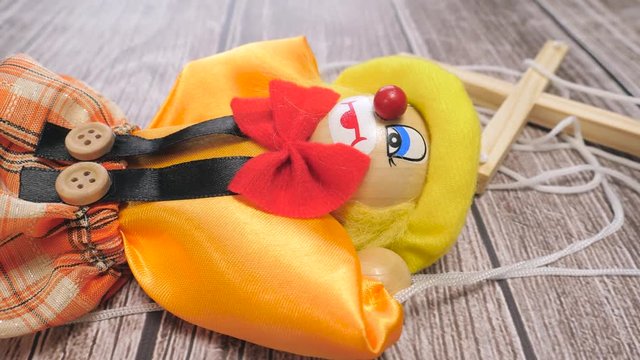 clown puppet laying on a table with the camera turning around it.