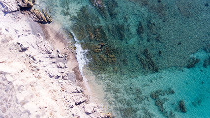 Sand, rock, and sea patterns on cristal clear waters.
