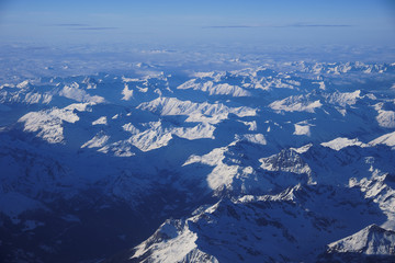 Bird's eye view of mountainscape covered in snow from an airplane