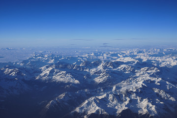 Bird's eye view of mountainscape covered in snow from an airplane