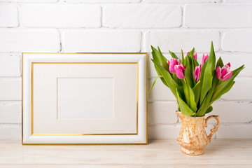 Gold decorated landscape frame mockup with bright pink tulips in golden vase