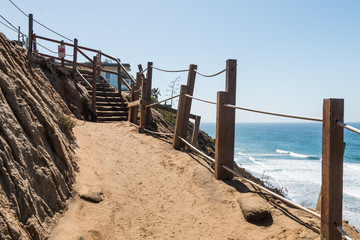 A dirt trail and stairs on the side of a cliff at Beacon's Beach in Encinitas, California.