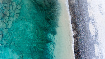 Sand, rock, and sea patterns on cristal clear waters.