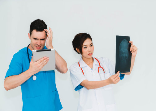 Couple doctors discussing and looking x-ray in a clinic or hospital