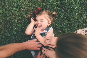 Young girl being tickled in the grass 