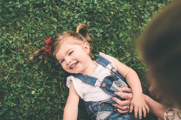 Young girl being tickled in the grass