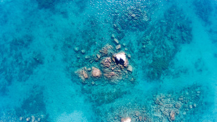 Sand, rock, and sea patterns on cristal clear waters.